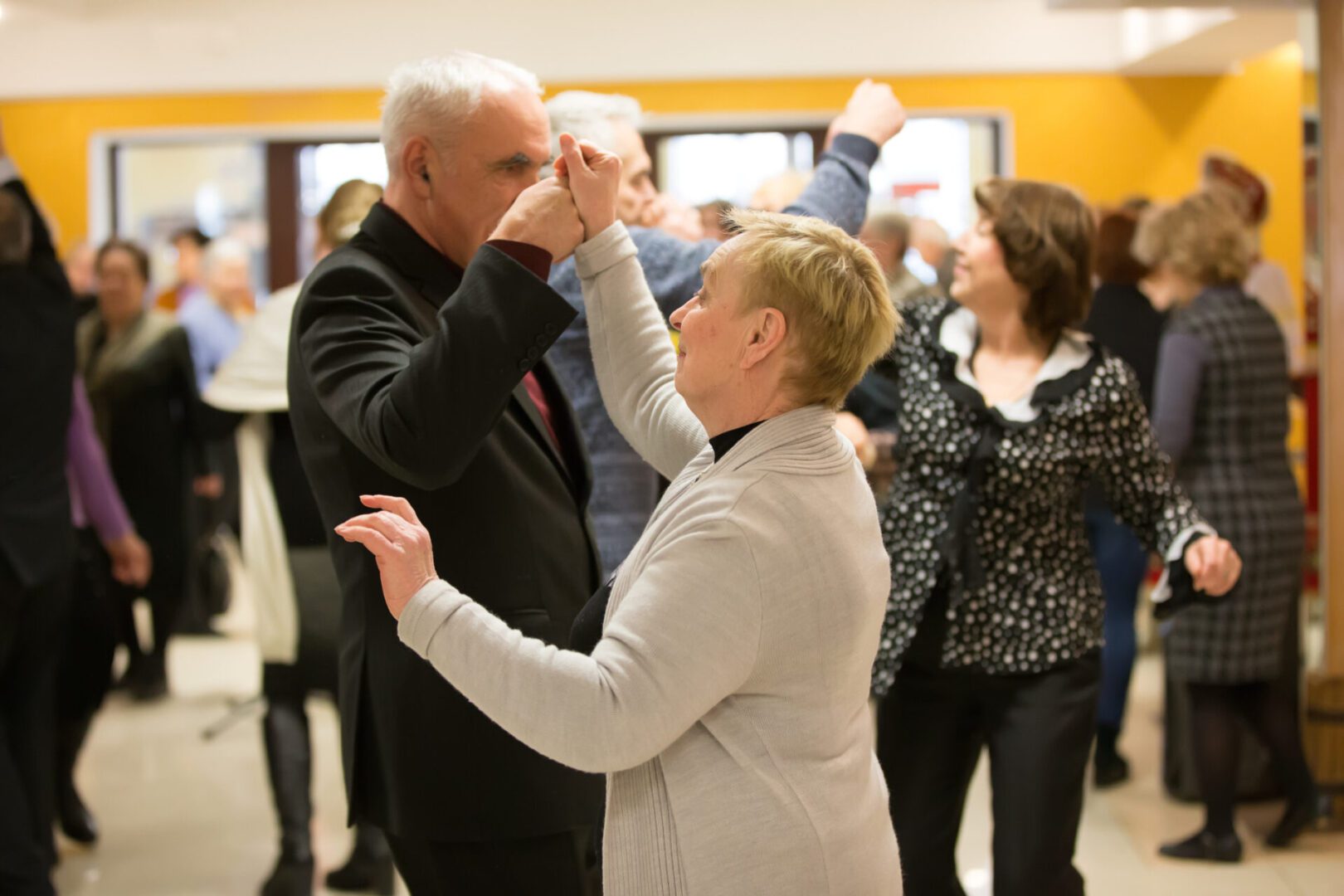 Elderly couple dancing at a social event.