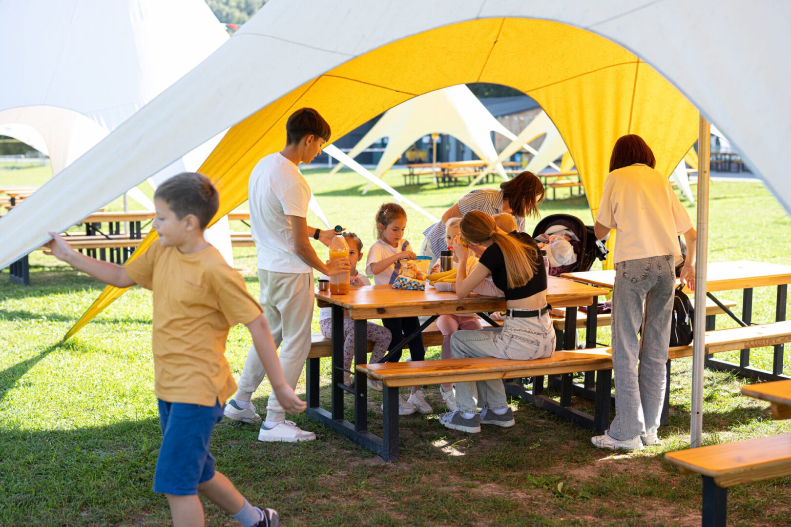 People enjoying a picnic under a tent.