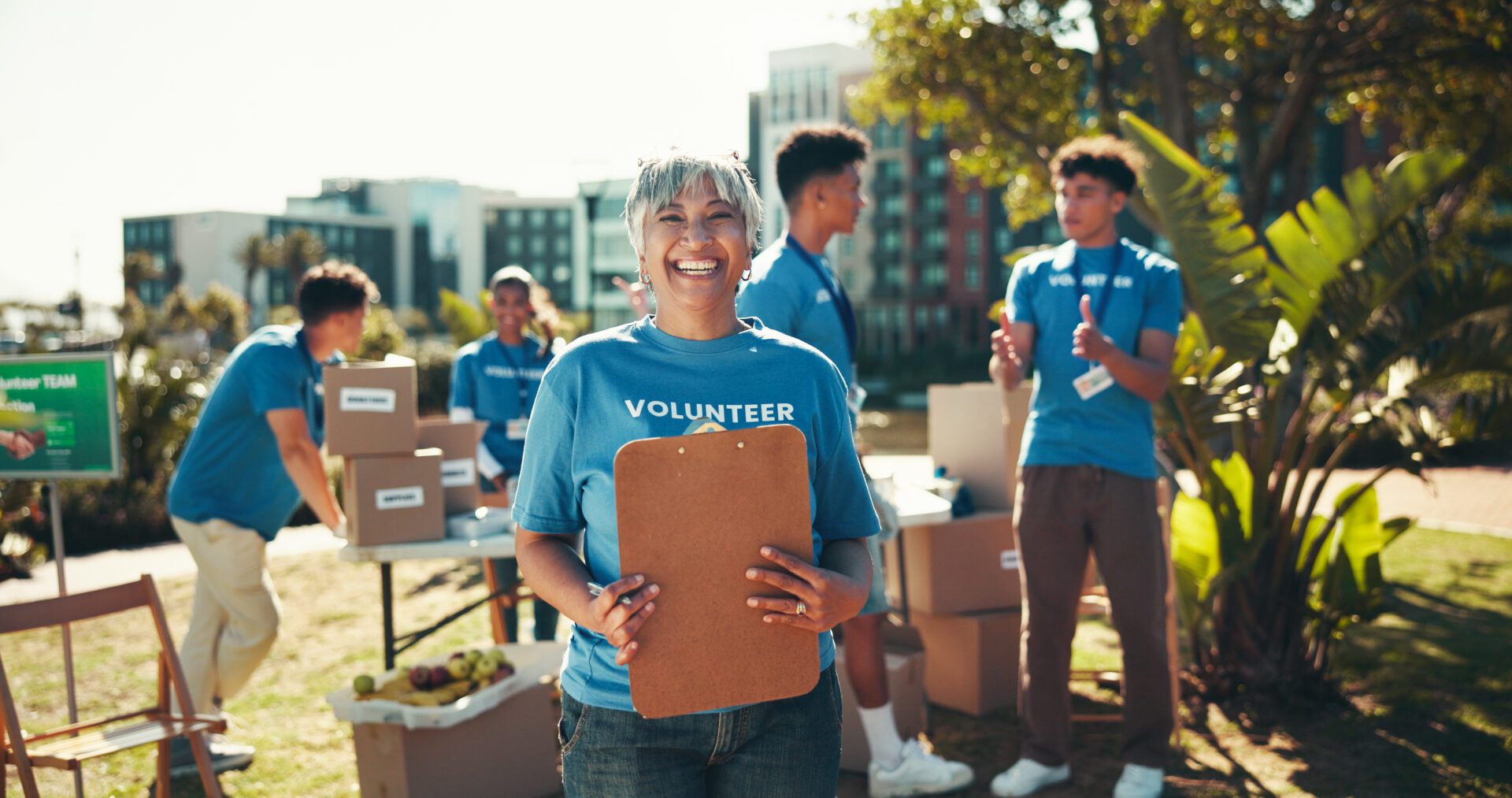 Volunteers organizing boxes outdoors on sunny day.