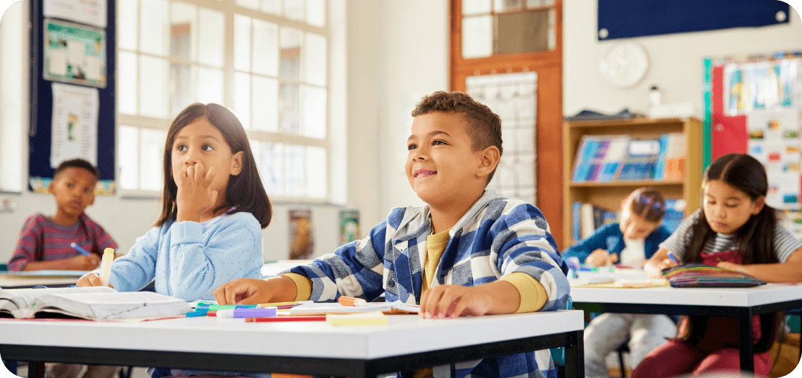 Children attentively listening in a classroom.