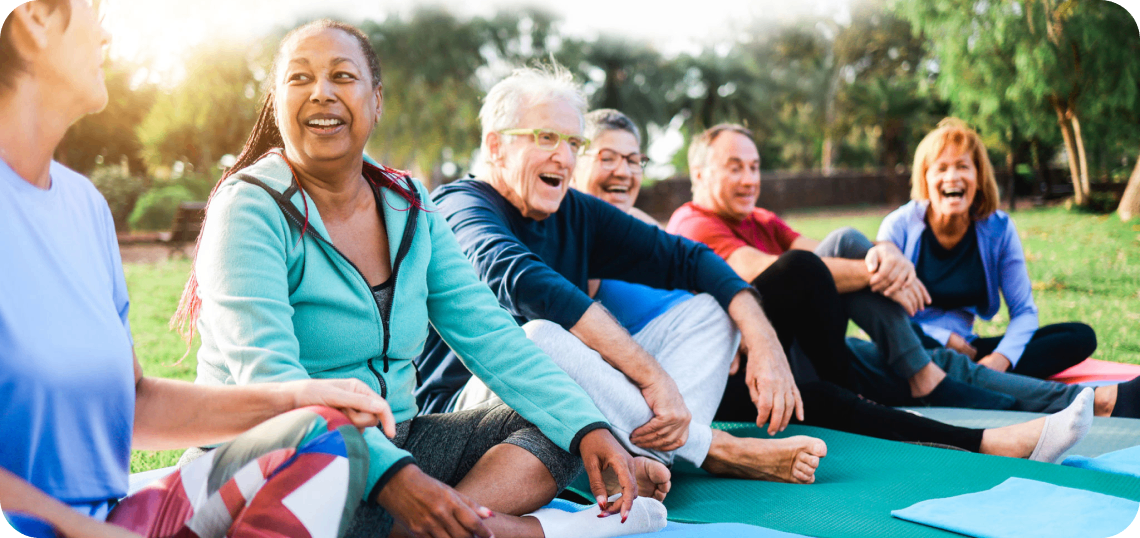 Group of people laughing during outdoor yoga.
