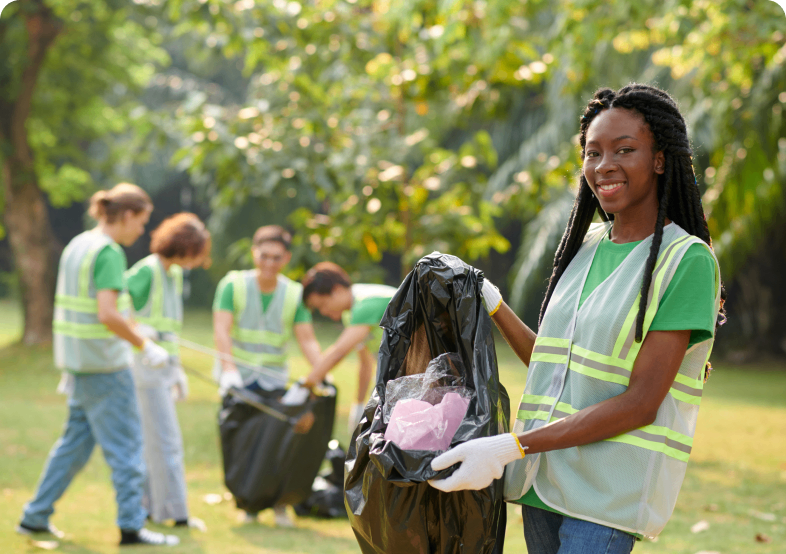 Group cleaning park with trash bags.