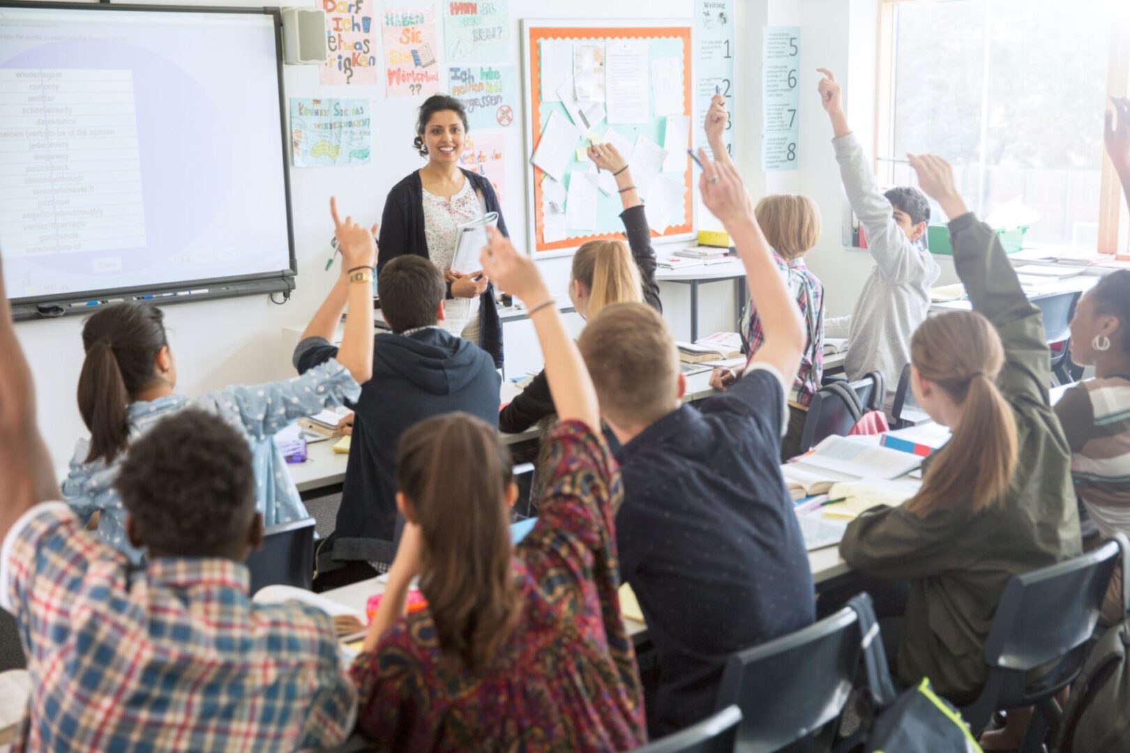 Students raising hands in a classroom session.