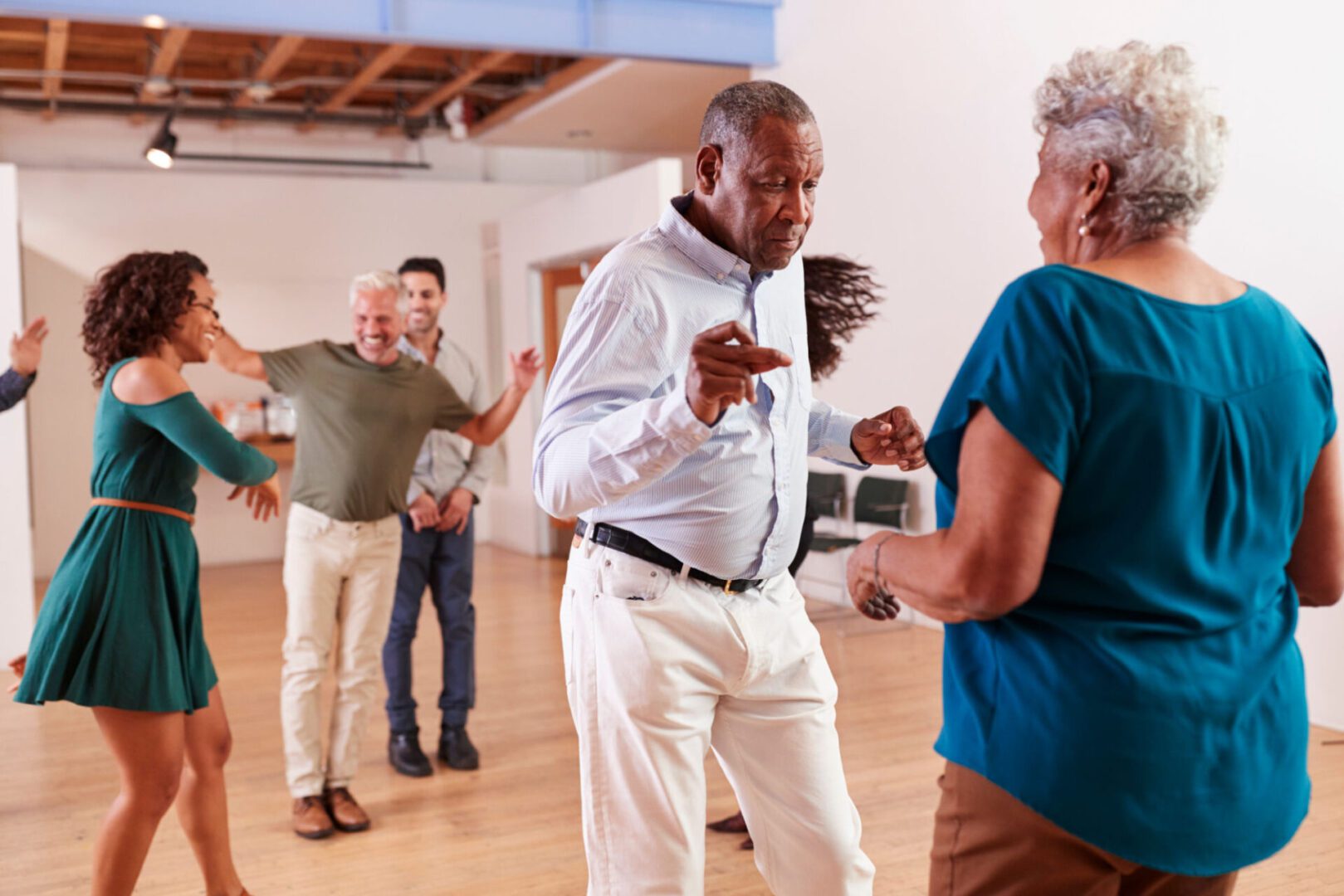People dancing joyfully in a bright room.