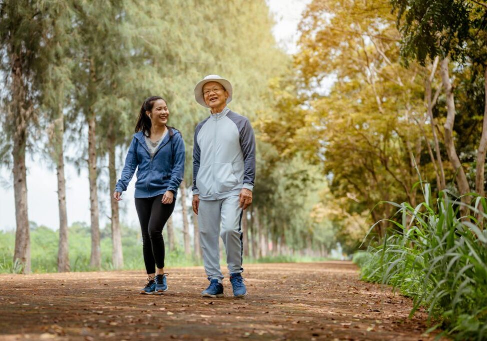 Man and woman walking in forest path.