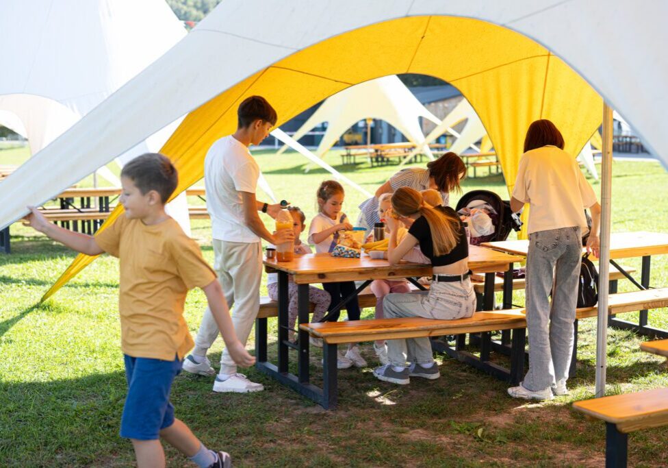 People enjoying a picnic under a tent.